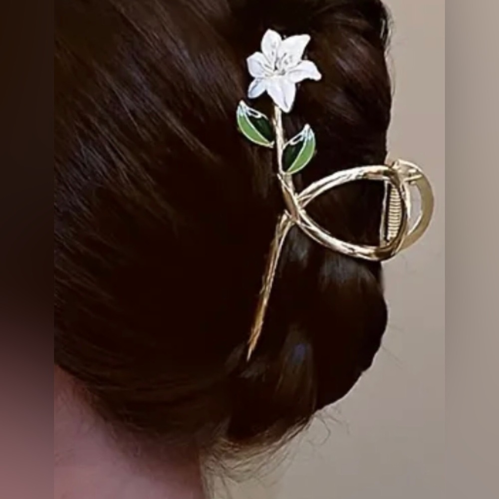 Elegant metal hair claw with enamel flower and leaves.